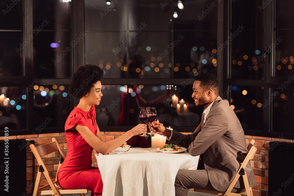 Couple Clinking Glasses Drinking Wine Celebrating Valentine's Day In Restaurant - obrazy, fototapety, plakaty 