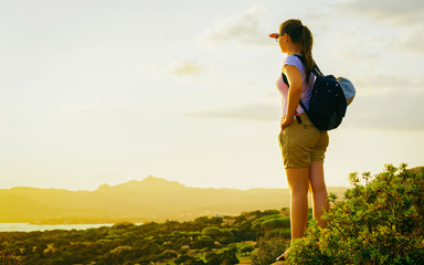 Wall Mural - Sunrise or sunset and young girl at Baja Sardinia of at Mediterranean sea in Sardinia island in Italy. Woman and Sardegna in summer.