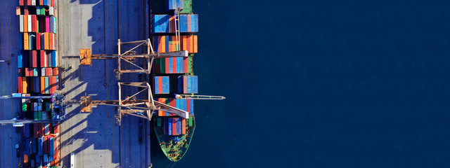 Aerial drone ultra wide top down photo of commercial container terminal with cranes loading shipment to tanker ships in Mediterranean port