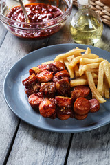 Wall Mural - Traditional German currywurst - pieces of sausage with curry sau