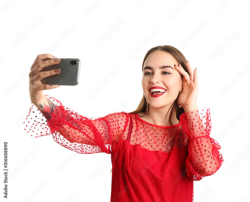 Beautiful young woman taking selfie on white background