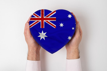 Wall Mural - Flag of Australia on a heart shaped box in a male hands. White background