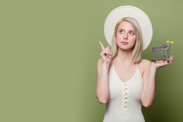 Wall Mural - Woman in white hat and dress with little shopping cart