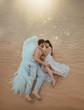 Men guardian angel protects and hugs young woman. Sleeping beauty vintage pastel color, miracle dream. Fabulous old warm sand desert nature. Bright sun shine light. Creative white suit design wing