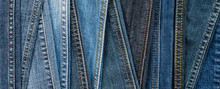 Denim background. Blue jeans seams of different shades and textures. Banner