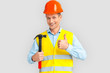 © Viktoriia - Construction. Mature man in hardhat and uniform standing isolated on white with hammer thumb up smiling happy