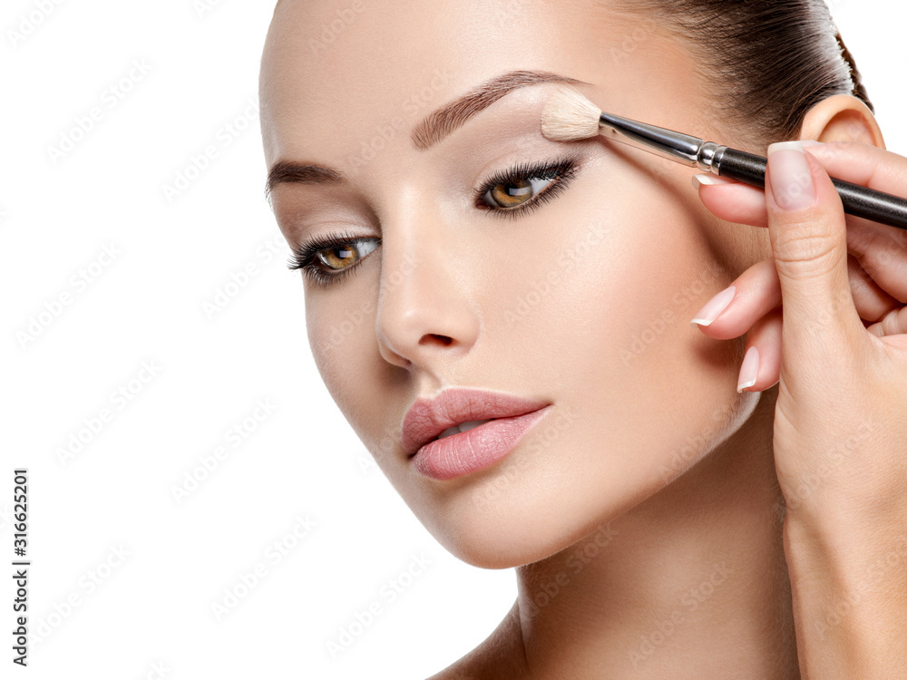 Beautiful woman applying eyeshadow use makeup brush - obrazy, fototapety, plakaty 