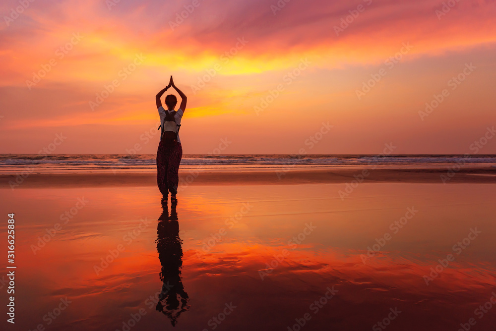 Beautiful yoga meditation reflection on water Goa beach on sunset - obrazy, fototapety, plakaty 