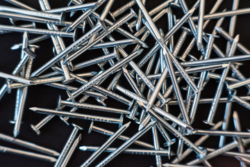 Wall Mural - metal construction nails close-up on black background