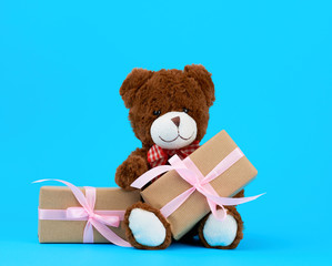 brown cute teddy bear and gifts wrapped in brown eco kraft paper and tied with a ribbon