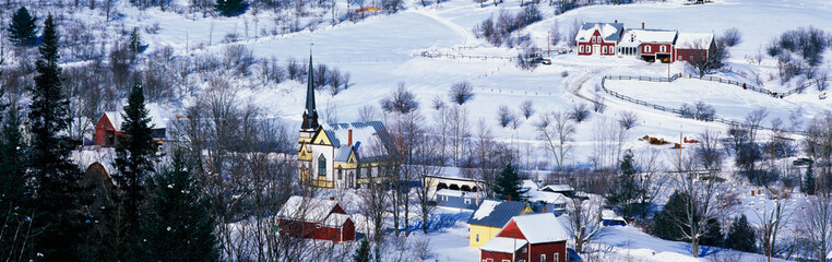 Wall Mural - This is an aerial view of East Orange. There is a black steepled church and a small village. The village is covered in snow with houses spread across the field.