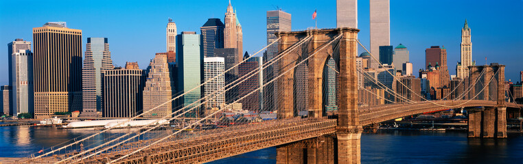 Wall Mural - This is a close up of the Brooklyn Bridge over the East River. The Manhattan skyline is behind it at sunrise.