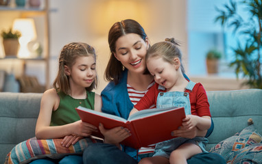 Wall Mural - mother reading a book to daughters