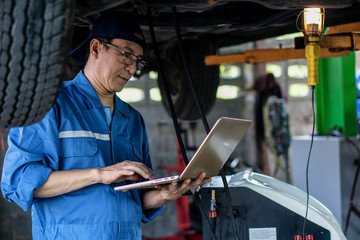 portrait of asian male car mechanic performing car checking and maintenace service at garage and car maintenance service station