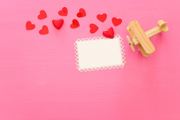 Wall Mural - Valentines day concept. red hearts over wooden pink background. Flat lay composition