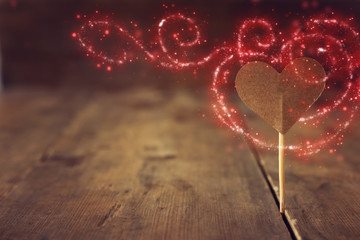 Wall Mural - Valentines day concept. one heart over wooden background and glitter lights