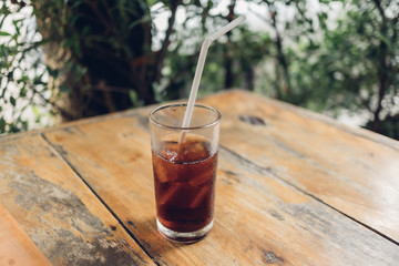 Glass of soda with a white straw on table.