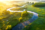 Aerial view of beautiful landscape of foggy river and green fields. Sunrise over river in summer