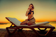 Beautiful girl model posing on a sunbed near the pool