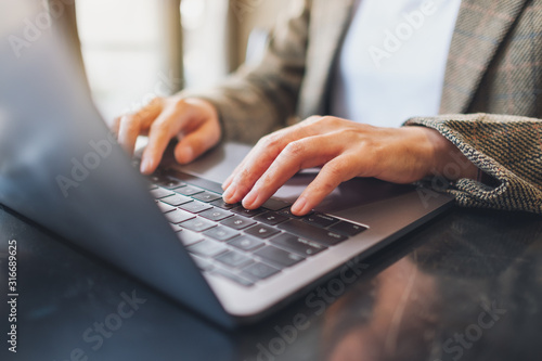 Fotografía Closeup image of a woman working and typing on laptop computer on the table