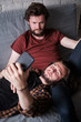 © sata_production - Two men taking selfie on the sofa