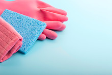 Rag And Pink Gloves On Blue Background With Copy Space.