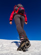 Woman hiker on a glacier with crampons on boots