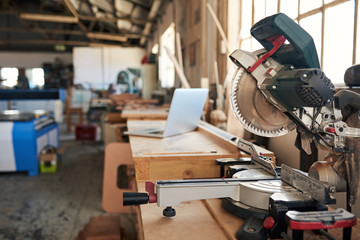 Wall Mural - Mitre saw and laptop on workbenches in a woodworking shop