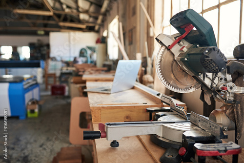 Cuadros en Lienzo Mitre saw and laptop on workbenches in a woodworking shop