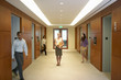 © moodboard - People walking in elevator lobby woman standing in middle