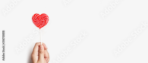 Photographie close up of heart lollipop on hand isolated on white background
