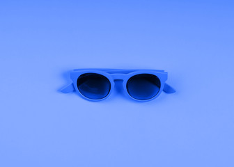 Canvas Print - Classic blue color of 2020 sun glasses. Monochrome minimal fashion flat lay.