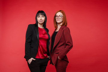 Waist up of beautiful businesswomen standing and posing at camera isolated on black background