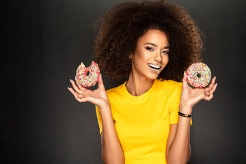 Wall Mural - Beauty fashion model girl taking sweets and colorful donuts. Funny joyful Vogue styled woman with sweets on pink background. Diet, dieting concept.