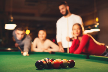  Group of friends play billiards at night out