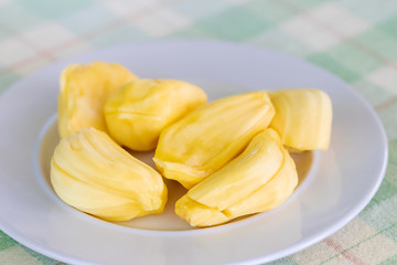 Wall Mural - Juicy ripe jackfruit slices on a white plate. Jackfruit is high in a few powerful antioxidants that provide various health benefits. (Exotic tropical fruit) 