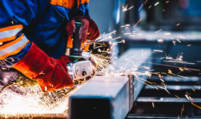 Wall Mural - Worker grinding in a workshop. Heavy industry factory