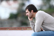 Pensive worried man sitting on a bench