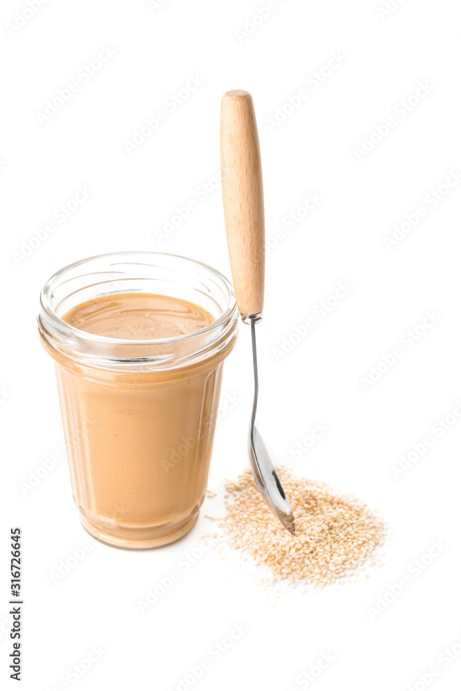 Jar of tasty tahini on white background