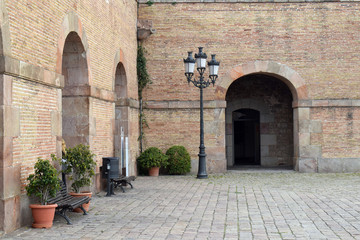 Old Stone Paved Courtyard with Pot Plants-Benches Lamppost & Stone Walls 