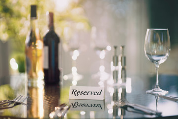 Wall Mural - Restaurant reserved table sign with place setting and wine glasses ready for a party