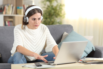 Serious female e-learning using headphones and laptop