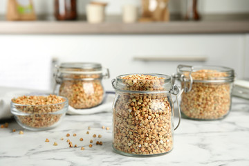 Sticker - Uncooked green buckwheat grains on white marble table