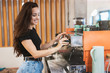 © studioprodakshn - young smiling barista woman working behind the bar, stands near professional coffee machine