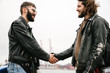 © Drobot Dean - Photo of bearded young men bikers smiling and handshaking