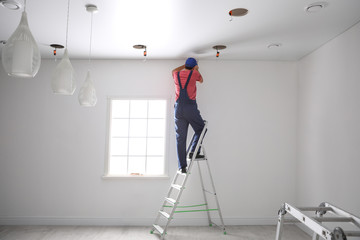 Sticker - Worker installing stretch ceiling in empty room