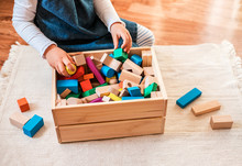 Little Girl Cleaning Up The Toy Box At Home. Child's Space Organization.