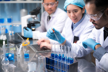 Wall Mural - asian scientist hold a test tube filled with liquid in the laboratory