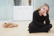 © MDBPIXS - Portrait of an upset girl sitting on hardwood floor by stuffed toy