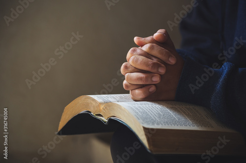Fotomural Hands folded in prayer on a Holy Bible in church concept for faith